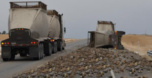 A loaded sugar beet truck slowly passes another driver who’s sugar beet truck turned over Sunday morning on I-94 at mile marker 4. Highway Patrol Trooper reported the accident was caused due to the driver’s fatigue. The accident was called into dispatch at 6:32am. It took crews a couple hours to remove all the remaining sugar beets in the trailer as well as pick up all the remaining beets alongside the Interstate. (Image by Jonathan McNiven) 